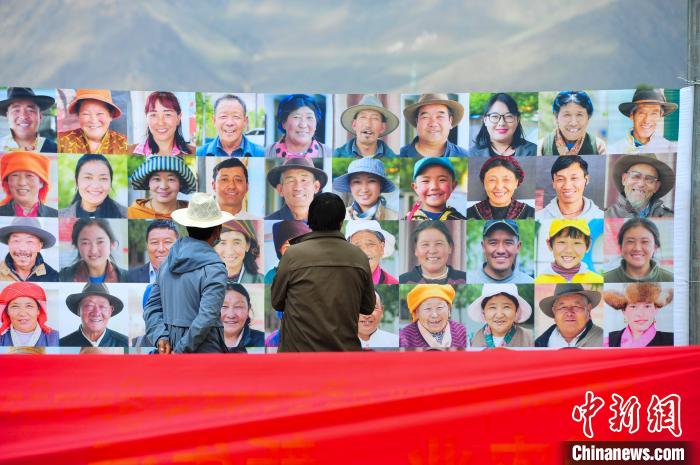 圖為當(dāng)?shù)孛癖娫谟^看展板上的笑臉。　張偉 攝