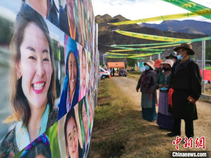 圖為當(dāng)?shù)孛癖娫谟^看展板上的笑臉?！垈?攝
