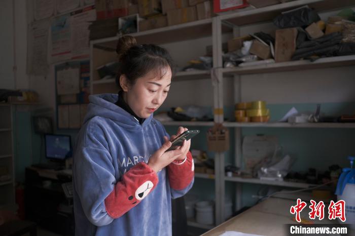 正在快遞站點(diǎn)內(nèi)忙碌的楊莉春?！『闻罾?攝