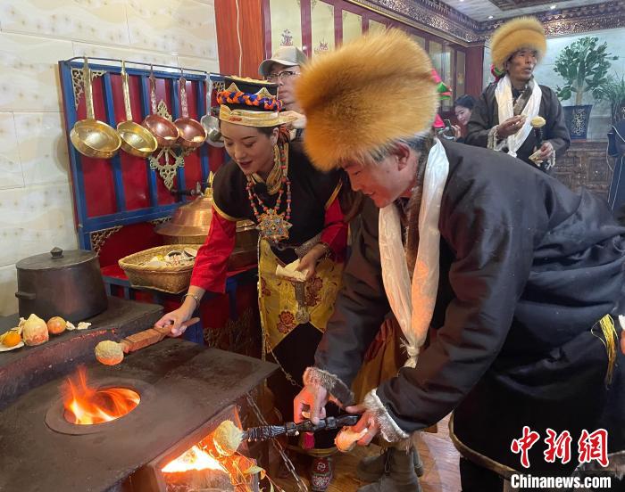 圖為人們?cè)诨鹕峡竟?jié)日美食“結(jié)達(dá)”?！∪轿木?攝