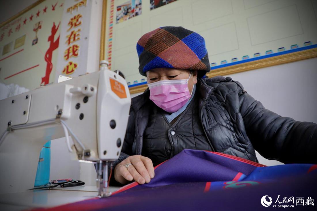 農(nóng)牧民專業(yè)合作社里的村民正在制作門簾。人民網(wǎng) 次仁羅布攝