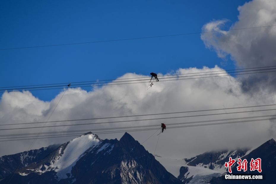 資料圖為2020年6月23日，西藏阿里聯(lián)網(wǎng)工程施工人員在日喀則希夏邦馬雪山附近進(jìn)行走線作業(yè)，安裝絕緣設(shè)備。 <a target='_blank' href='/'><p  align=