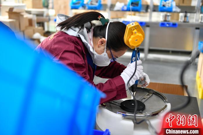 圖為工人正在組裝炊具?！∝暩聛硭?攝