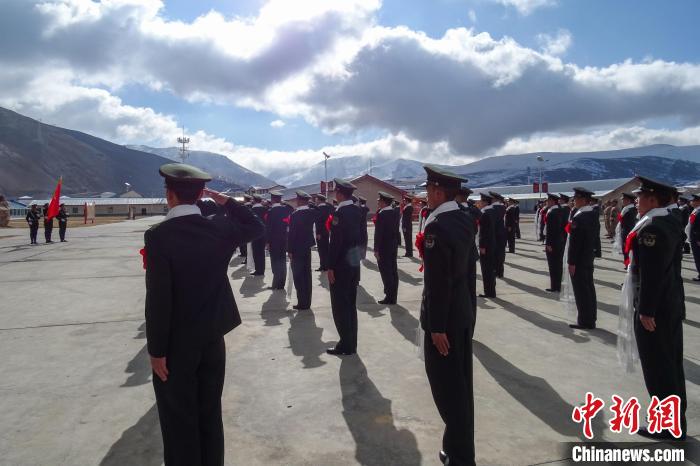 雪山下，退役士兵向軍旗敬軍禮。　李學(xué)文 攝