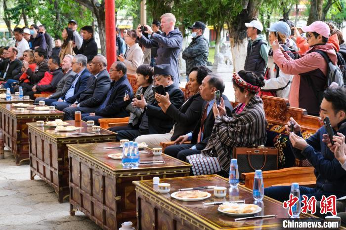 5月19日，中外嘉賓在羅布林卡和游客一起觀看藏戲?！〗w波 攝