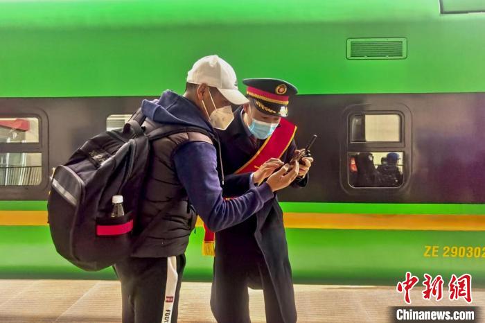 圖為日喀則火車站工作人員服務(wù)乘客。　斗山得 攝