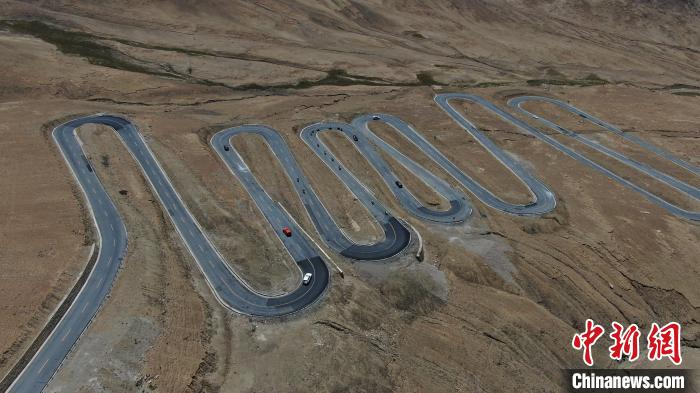 圖為騎手前往珠峰大本營途經(jīng)108道拐?！∮文恋厍蚬﹫D