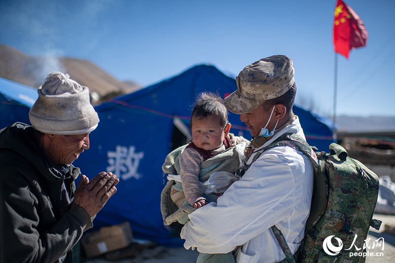 1月9日，在定日縣長所鄉(xiāng)古榮村安置點，受災群眾感謝西藏軍區(qū)陸軍某部隊衛(wèi)生員的醫(yī)療救治。人民網記者 翁奇羽攝