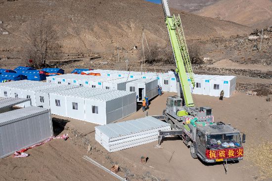 2025年1月9日，在定日縣長(zhǎng)所鄉(xiāng)古榮村安置點(diǎn)，救援人員和施工人員合力抓緊搭建移動(dòng)板房，確保受災(zāi)群眾溫暖過冬。人民網(wǎng)記者 翁奇羽攝
