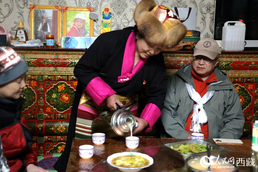 扎西曲登社區(qū)的居民在家中熱情招待遠(yuǎn)道而來(lái)的游客。居民身著盛裝，為游客倒上熱騰騰的酥油茶，桌上擺放著切瑪與特色美食，賓主共話民族團(tuán)結(jié)情誼。人民網(wǎng)記者 吳雨仁攝