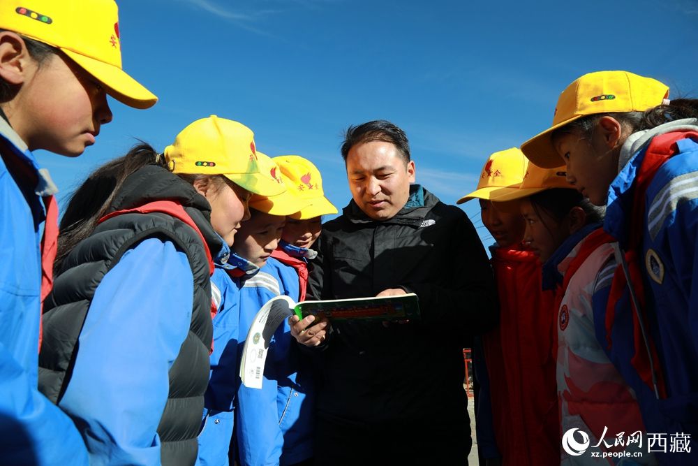 西藏自治區(qū)藏醫(yī)院專家為拉東村小學(xué)生講解天文歷算原理，孩子們圍站聆聽，感受傳統(tǒng)智慧與現(xiàn)代科普的融合。人民網(wǎng)記者 吳雨仁攝
