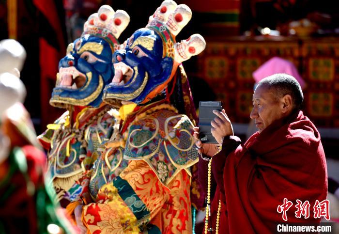 2月19日，正在拍攝跳神活動(dòng)的僧人?！±盍?攝